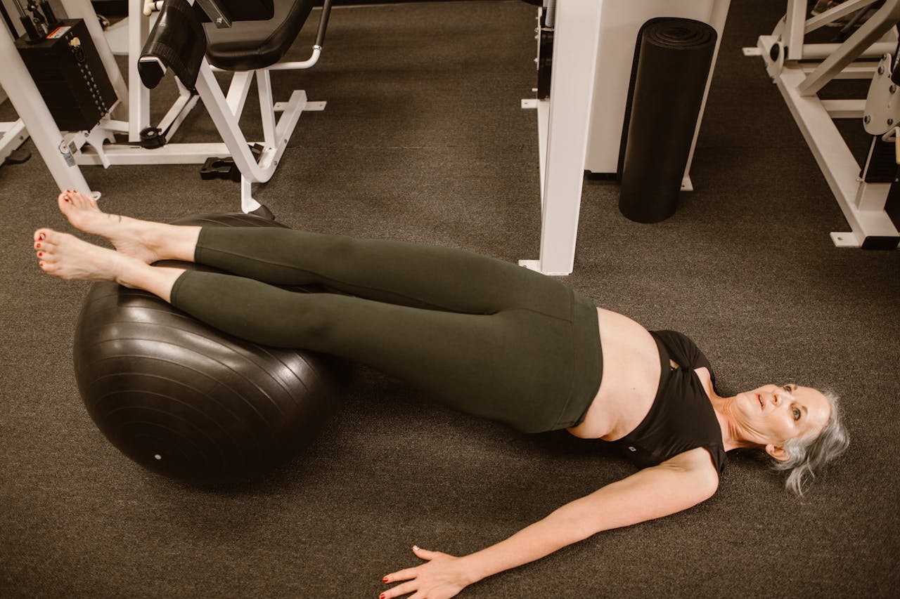 Senior woman performing exercise with a stability ball, promoting healthy lifestyle and fitness.